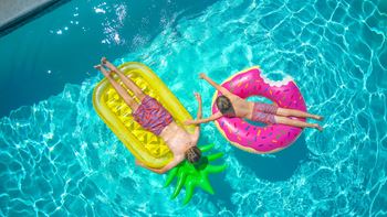 people floating on inflatable floats in Reveal Heathrow swimming pool